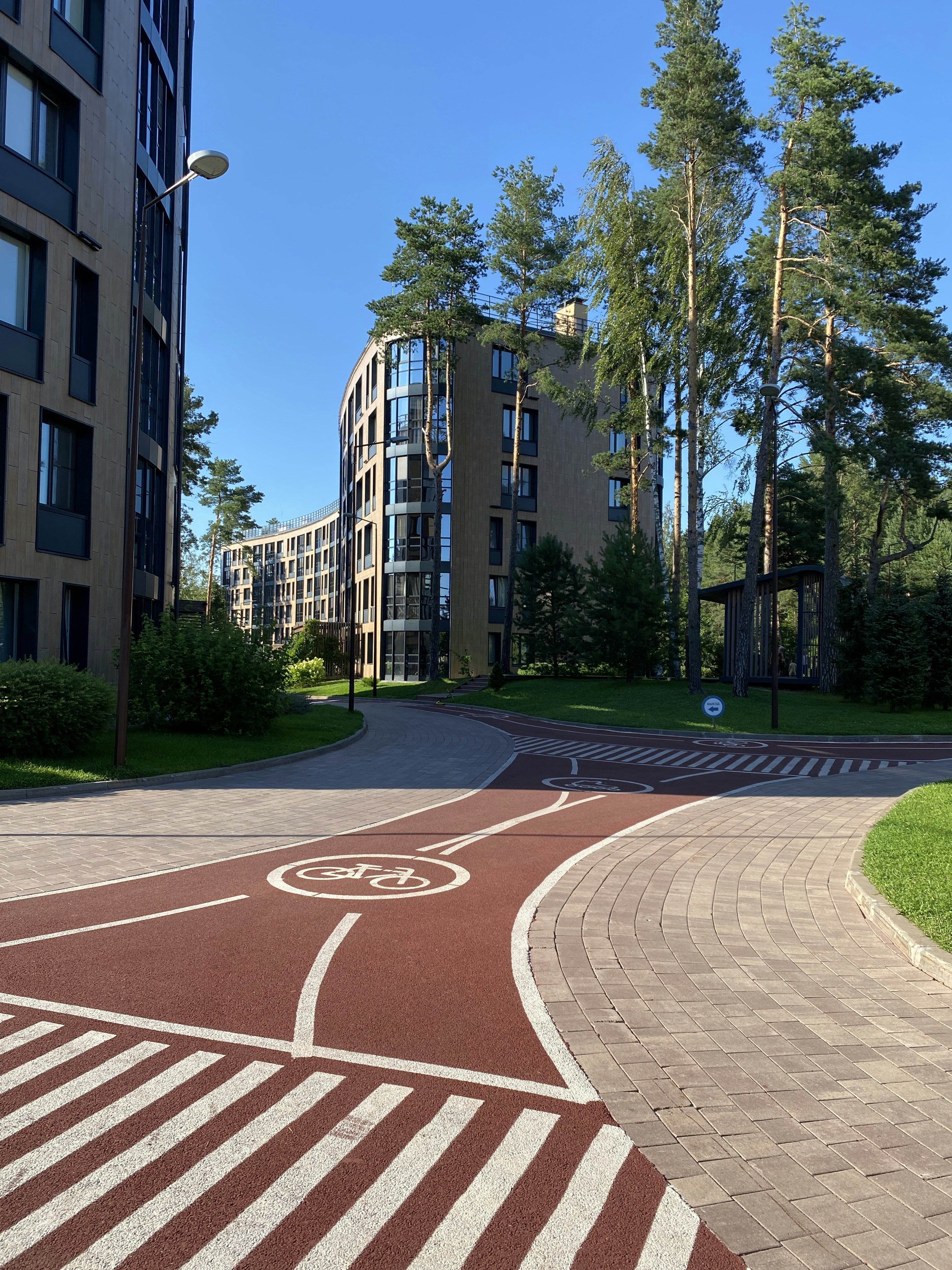 Modern apartment building surrounded by mature trees near a university campus