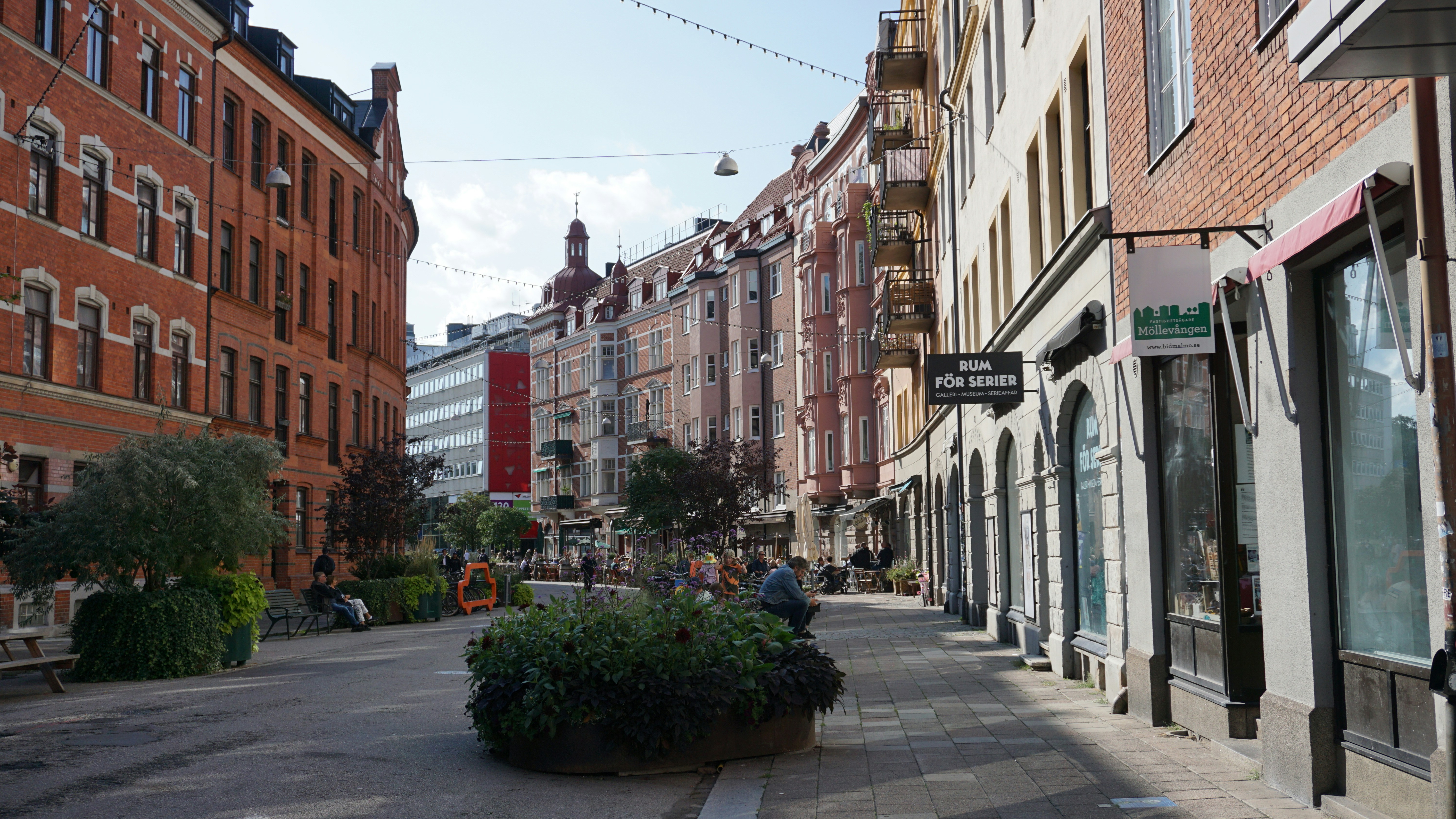 Vibrant downtown street scene with brick buildings and outdoor café seating